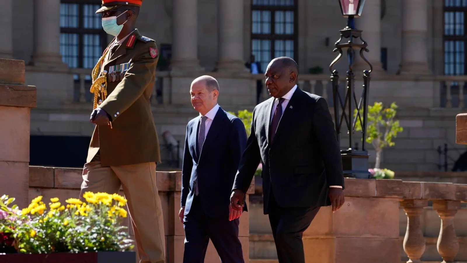 Bundeskanzler Olaf Scholz (M, SPD), und Cyril Ramaphosa (r), Präsident von Südafrika, nach einer offiziellen Begrüßungszeremonie auf dem Gelände des Union Building, dem Regierungssitz Südafrikas in Pretoria. (Foto: Themba Hadebe/AP/dpa)