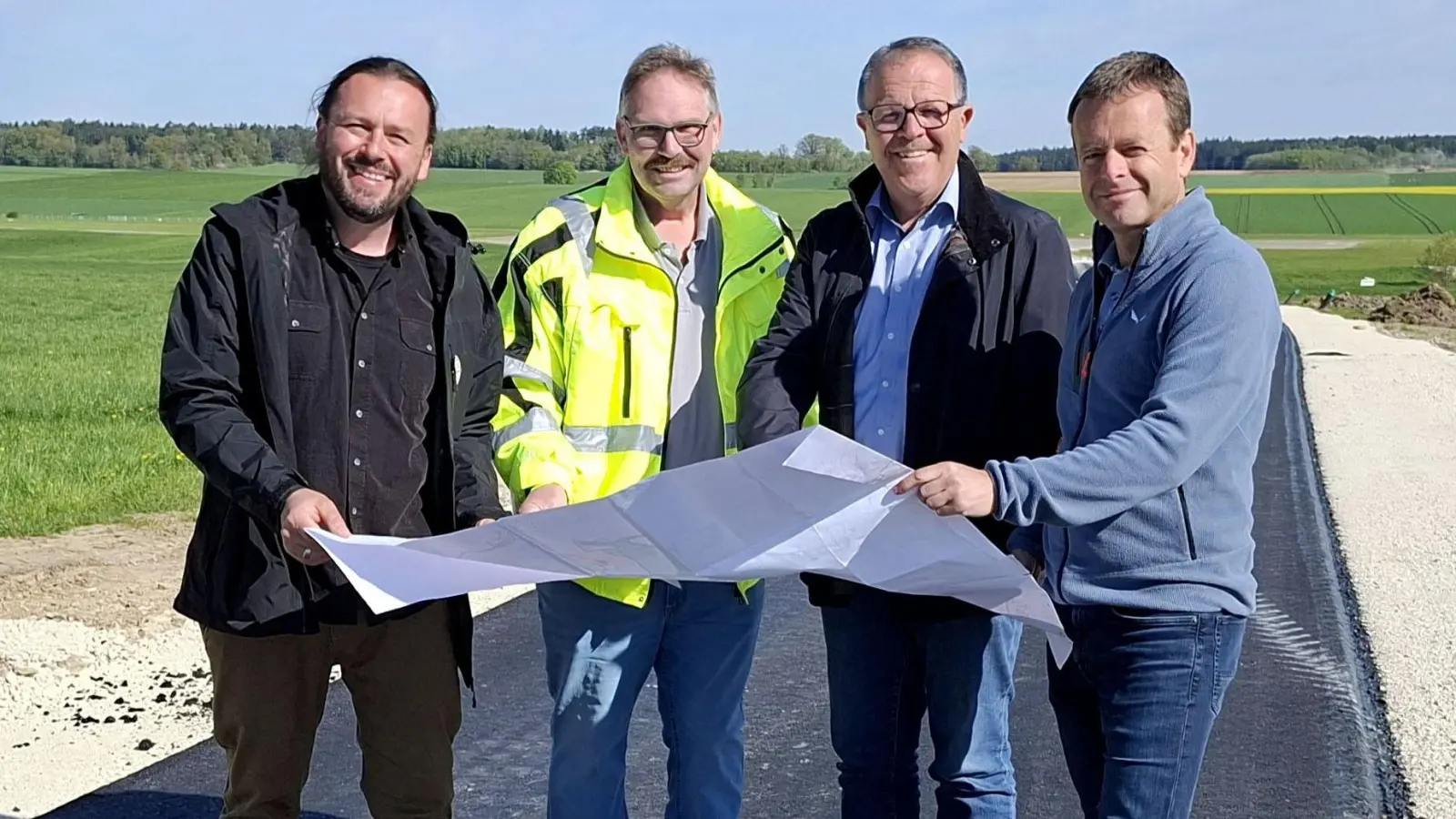 Werfen gemeinsam einen Blick auf den Plan (von links): Manuel Kiesel, Projektleiter für Bauinfrastruktur und Geländeplanung beim Summer Breeze, Hans Gärtner vom Verband für Ländliche Entwicklung Mittelfranken, der ehemalige Bürgermeister von Wittelshofen Werner Leibrich und Thomas Himml vom ALE. (Foto: Diane Mayer/ALE)