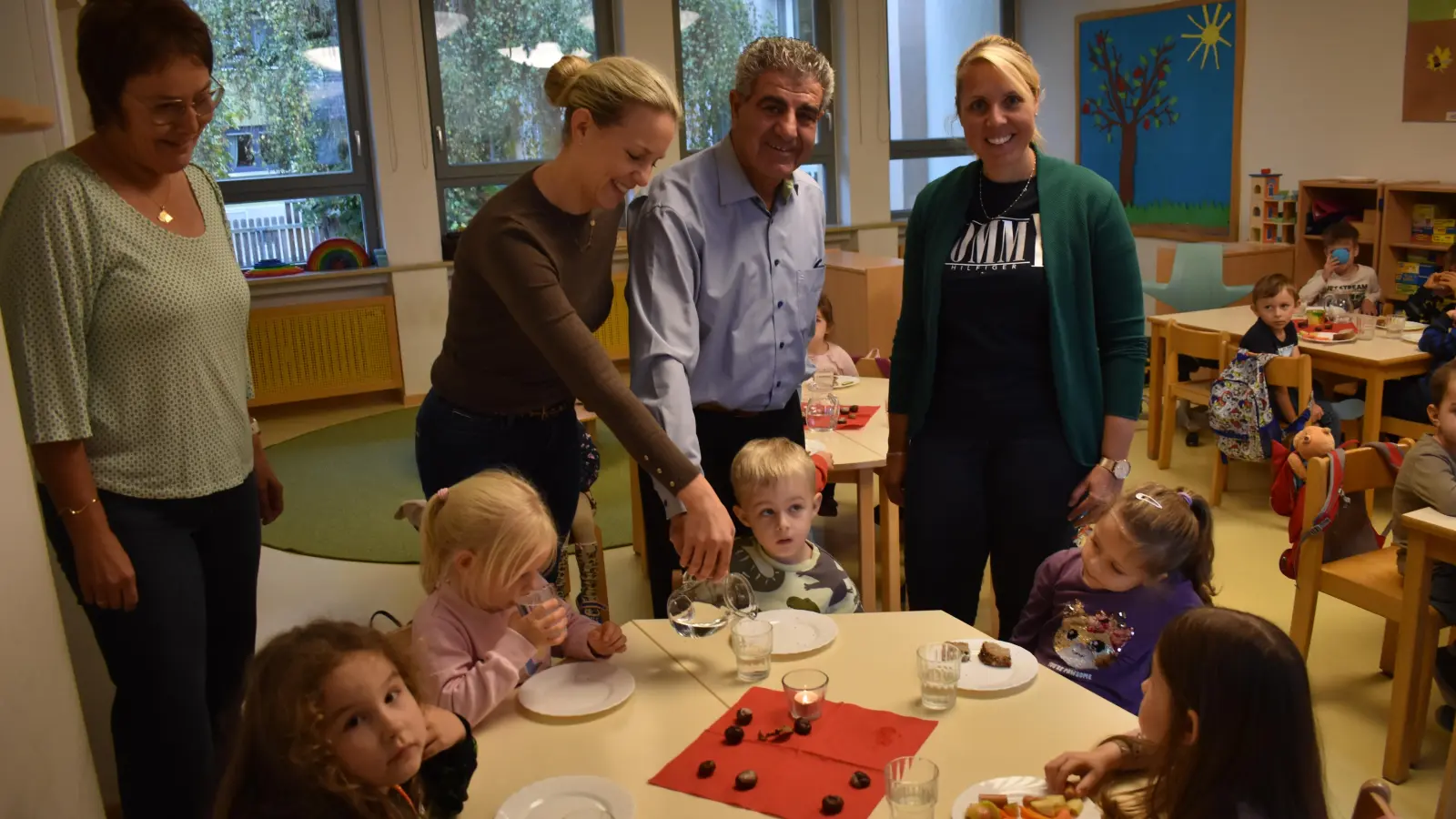 Viele Kinder trinken Wasser zum Essen. Maria Meinzinger (links) und Sabine Weisbach (rechts) von der Kita-Leitung freuen sich darüber ebenso wie Dr. Katharina Jashari und Dr. Faheem Saa. (Foto: Ute Niephaus )