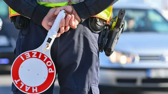 Ein Polizeibeamter hält eine Winkerkelle in den Händen. (Foto: Patrick Pleul/dpa-Zentralbild/ZB/Symbolbild)