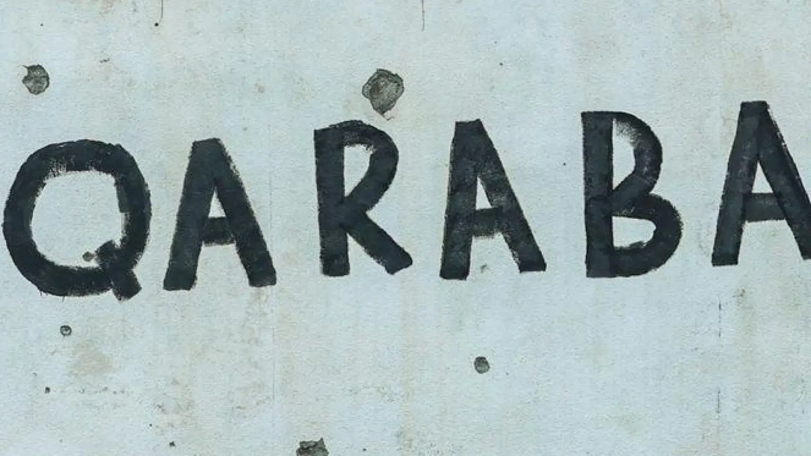 Spuren des Konflikts: Wand mit Einschusslöchern und dem Schriftzug Karabach. (Foto: Aziz Karimov/AP/dpa)