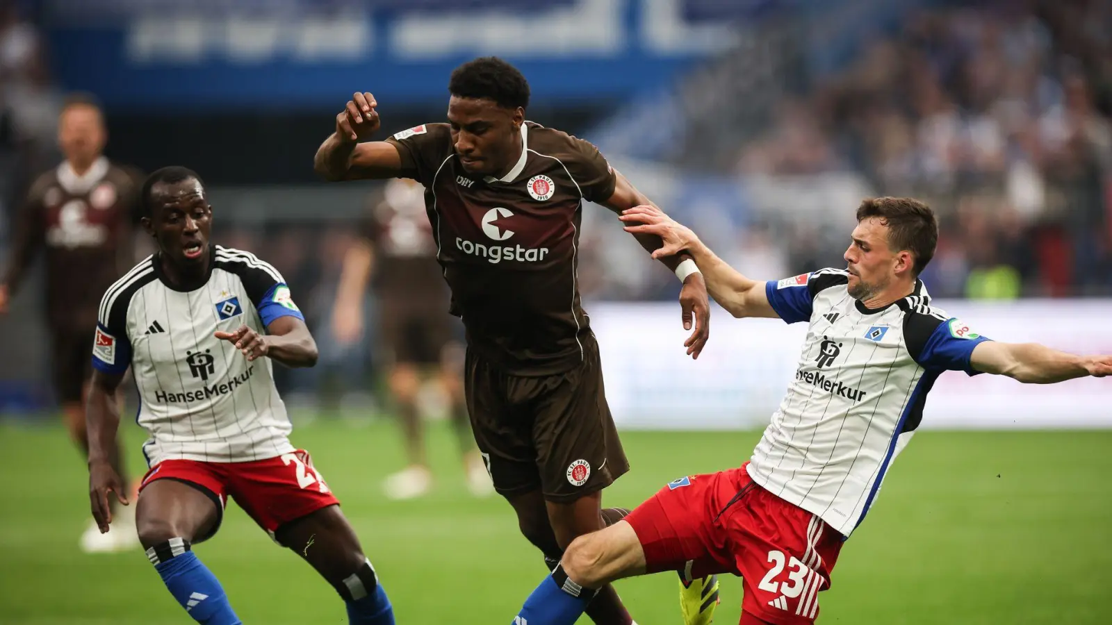 Voll dabei: St. Paulis Oladapo Afolayan (M) kämpft mit Hamburgs Jean-Luc Dompe (l) und Hamburgs Jonas Meffert um den Ball. (Archiv) (Foto: Christian Charisius/dpa)