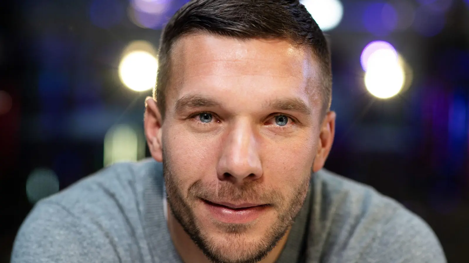 Der frühere Fußball-Nationalspieler Lukas Podolski lächelt in die Kamera. (Foto: Bernd Thissen/dpa)