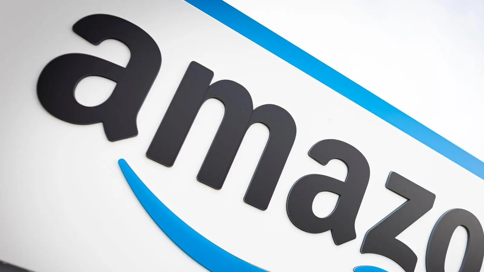 Das Logo von Amazon ist am Logistikzentrum des Onlineversandhändlers zu sehen. (Foto: Moritz Frankenberg/dpa)