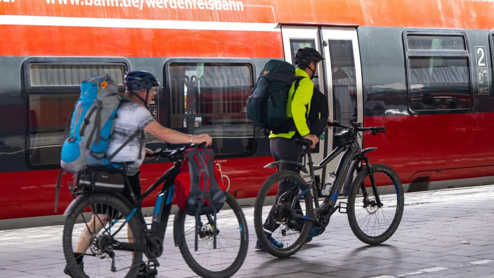 Reisende schieben am Hauptbahnhof in München ihre Fahrräder über den Bahnsteig. (Foto: Lennart Preiss/dpa)