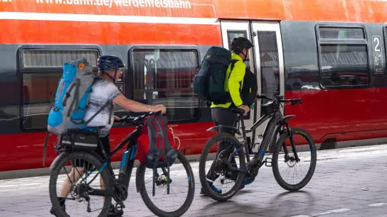 Reisende schieben am Hauptbahnhof in München ihre Fahrräder über den Bahnsteig. (Foto: Lennart Preiss/dpa)