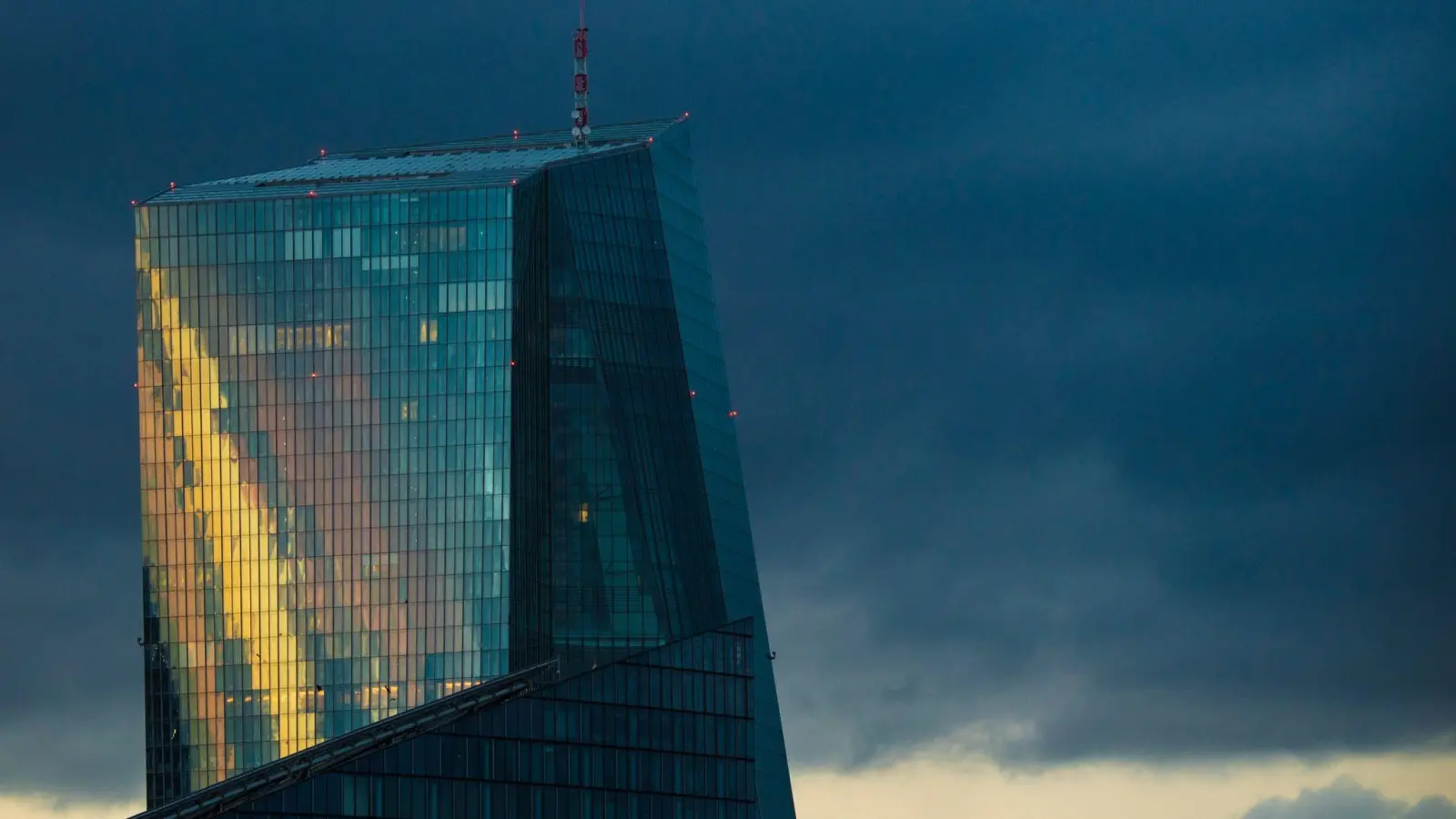 Das Licht der untergehenden Sonne spiegelt sich in der Glasfassade der Europäischen Zentralbank (EZB). (Foto: Boris Roessler/dpa)