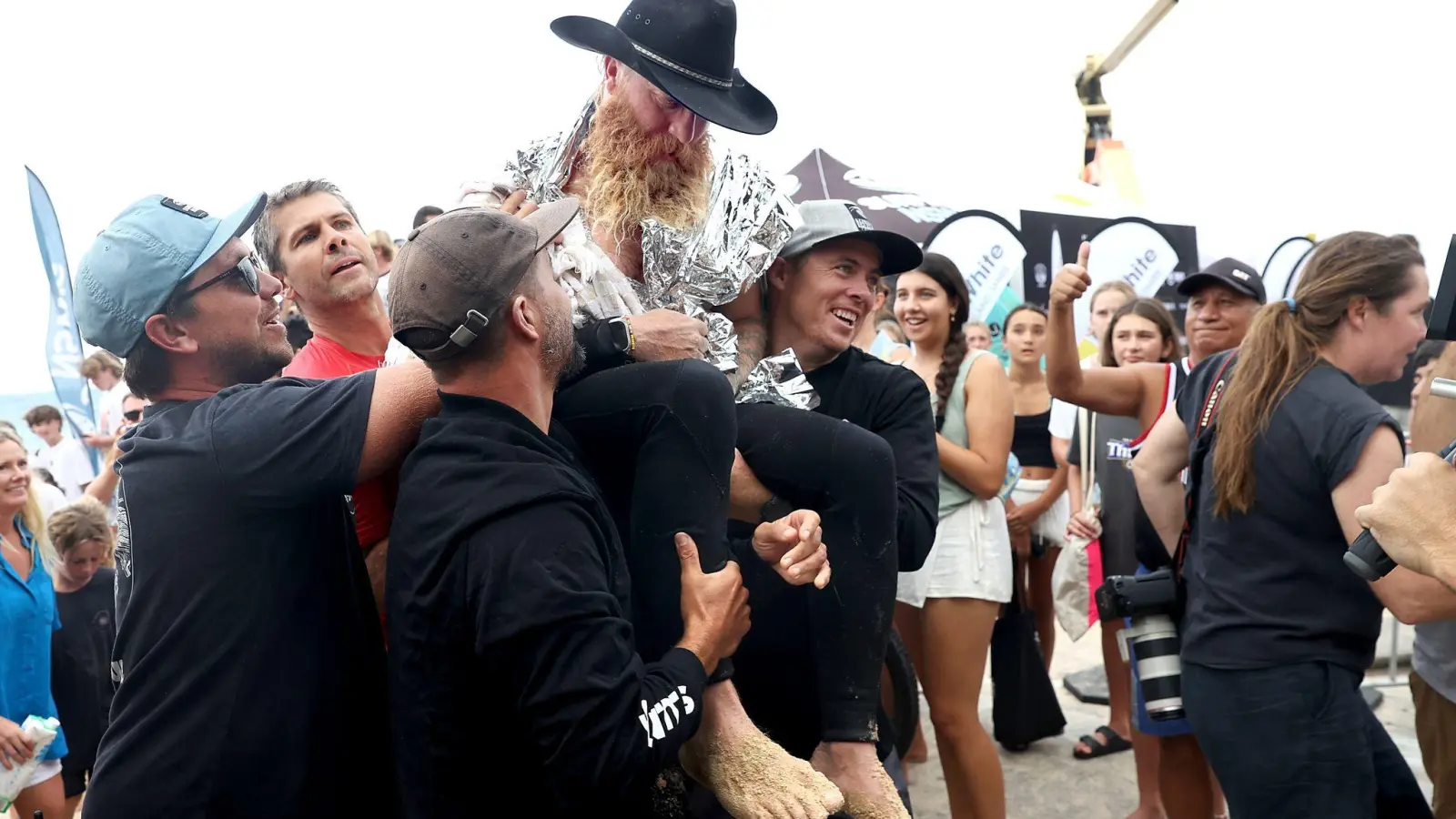 Der erschöpfte Blake Johnston wird von Freunden und Betreuern getragen, nachdem er den längsten Surf-Weltrekord von 500 Wellen in 40 Stunden vor der Küste Sydneys überboten hat. (Foto: Jane Dempster/AAP/dpa)