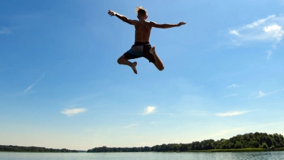 Ein Mann springt in einen See. (Foto: Patrick Pleul/dpa-Zentralbild/dpa/Symbolbild)