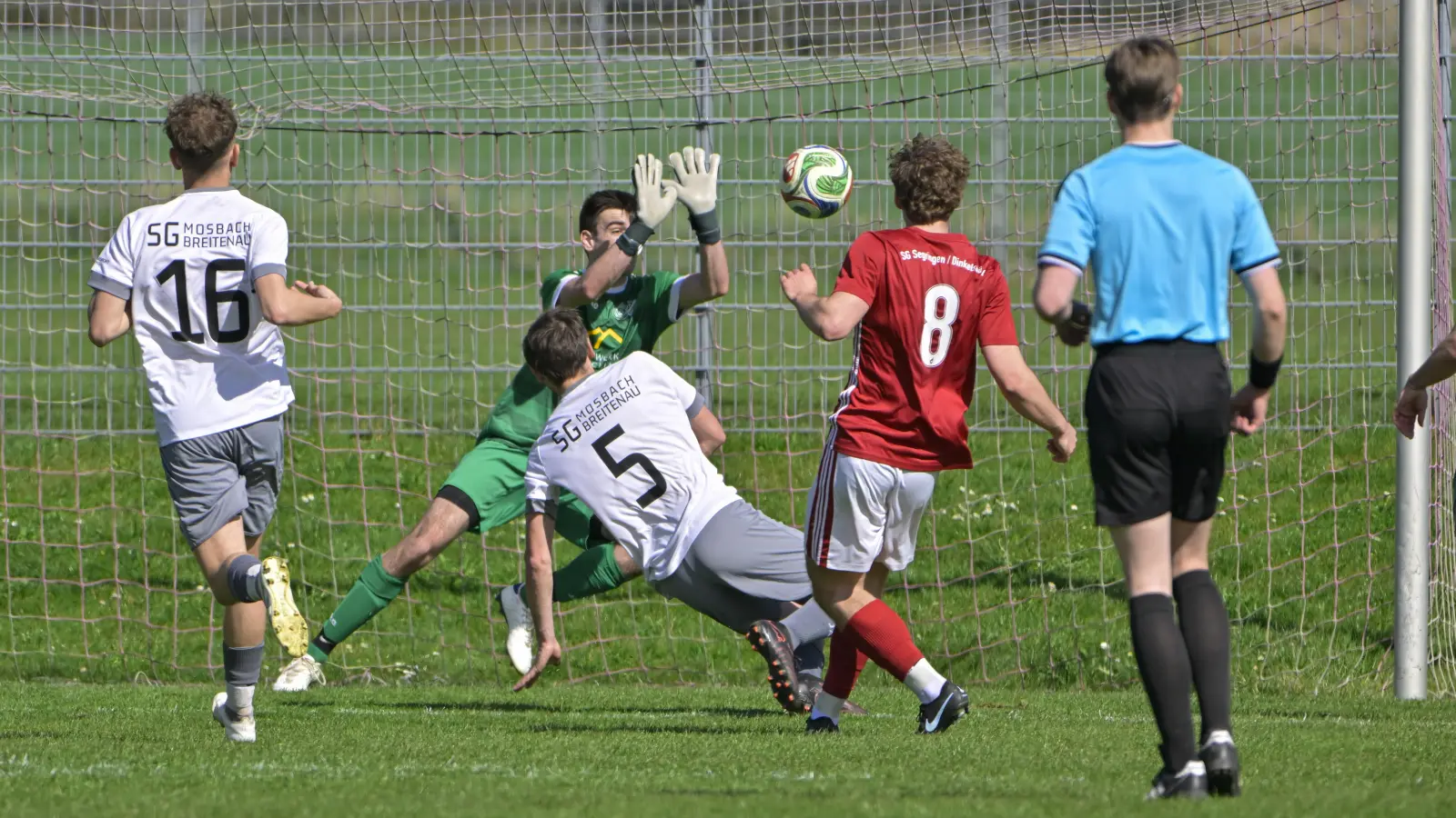Julian Frickinger (im roten Trikot) erzielt hier das 2:1 für die SG Segringen/Dinkelsbühl bei der SG Mosbach-Breitenau (von links Tim Bender, Torwart Joshua Perlefein und Alexander Schneider. Der Endstand lautete 3:3. (Foto: Martin Rügner)