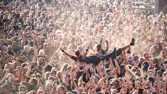 Crowdsurfen in Wacke. Das WOA gilt als größtes Heavy-Metal-Festival der Welt. (Foto: Daniel Reinhardt/dpa)