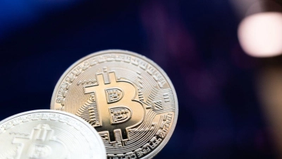 Bitcoin-Münzen liegen auf einem Tisch. (Foto: Hannes P Albert/dpa)