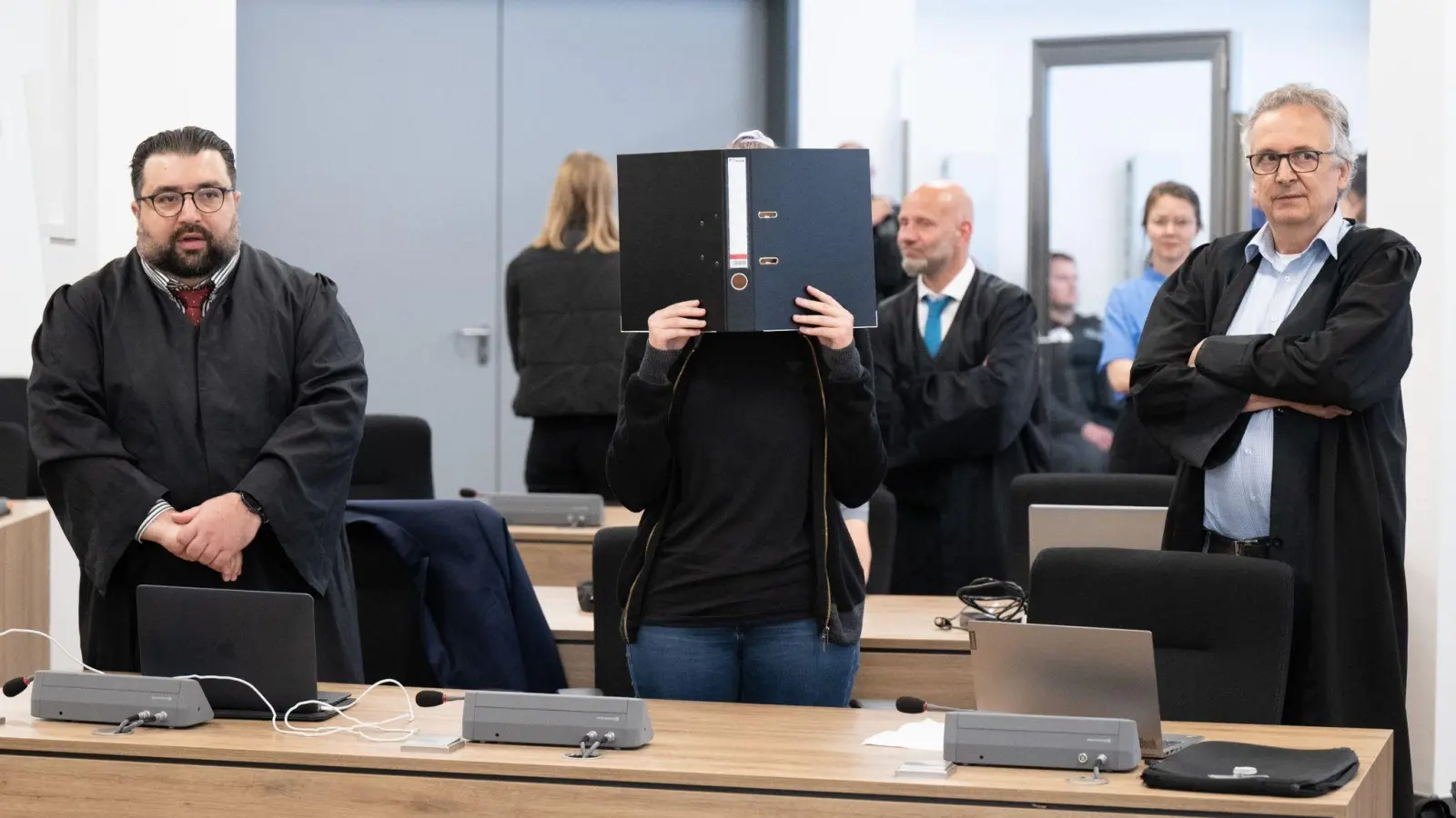 Die Angeklagte (M) steht bei der Fortsetzung des Prozesses im OLG Dresden im Verhandlungssaal. (Foto: Sebastian Kahnert/dpa)