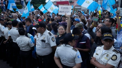 Während einer Demonstration in der Hauptstadt hält eine Frau ein Schild mit der Aufschrift „Parasiten raus“ in die Höhe. Tausende Menschen protestieren in Guatemala gegen die Generalstaatsanwaltschaft. (Foto: Moises Castillo/AP/dpa)