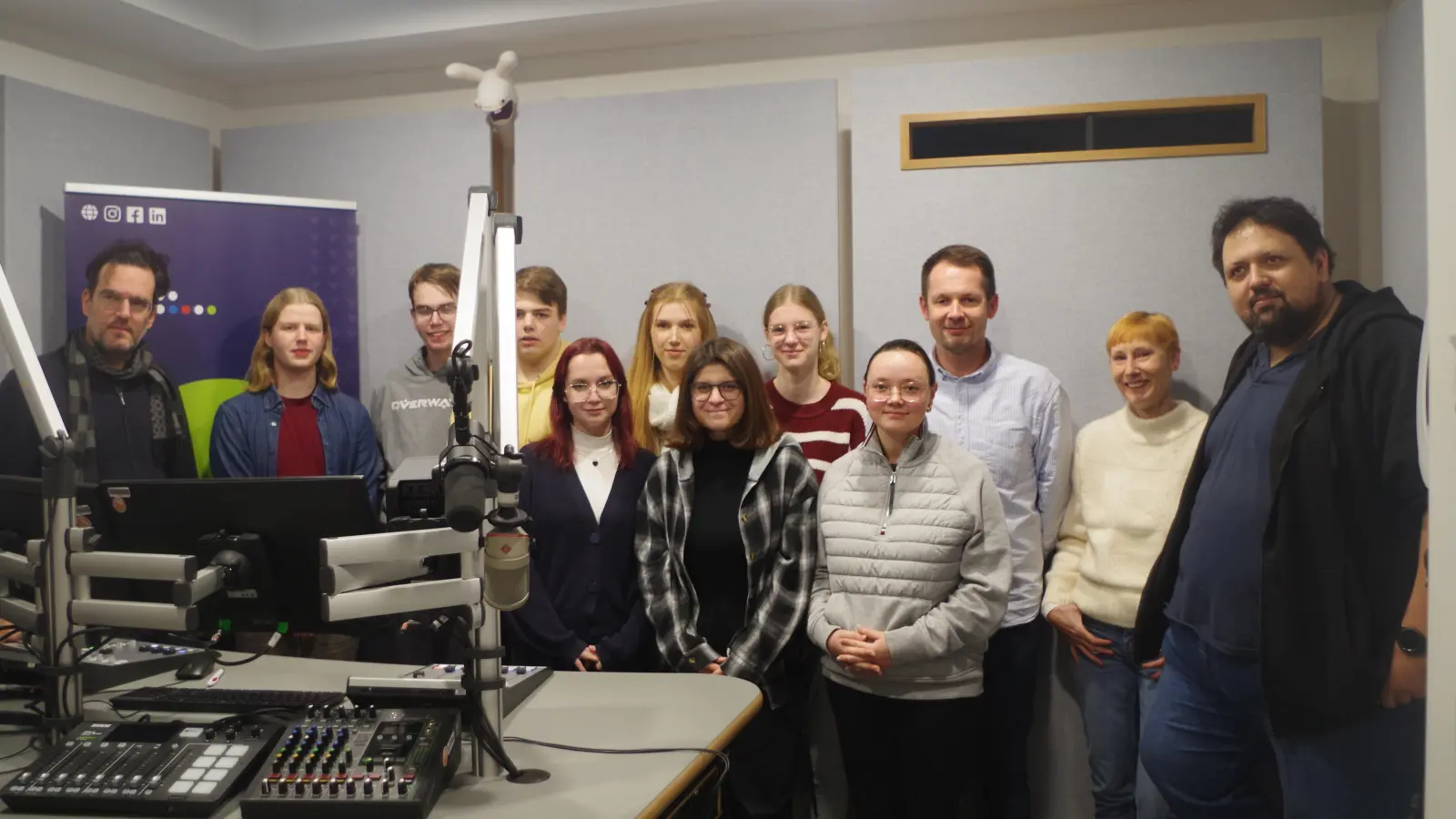 Für eine gemeinsame Sendung im Studio: Links im Bild sind Studiotechniker Gerald Gerner und Rabbit-Redakteur Finn Sanders zu sehen. Erster von rechts ist Sergej Kachatryan vom Hochschulradio, daneben die stellvertretende Schulleiterin der FOS Triesdorf, Alexandra Zink, und Lehrer Johannes Loy, dazwischen Schülerinnen und Schüler. (Foto: Jannic Hofmuth)