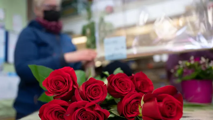 Eine Floristin bereitet in einer Blumenhandlung einen Valentinsstrauß aus roten Rosen vor. (Foto: Bernd Thissen/dpa/Archivbild)