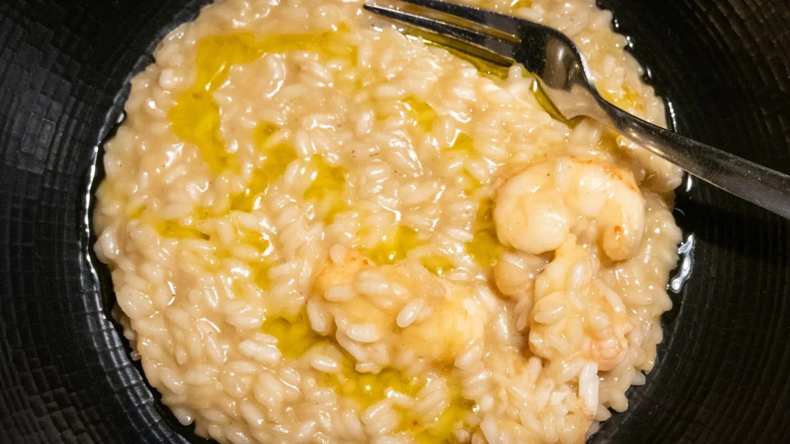 Kurz vorm Servieren gibt Küchenchef Kruno Kapetanović noch einen Schuss Olivenöl über das Scampi-Risotto. (Foto: Andreas Drouve/dpa-tmn)