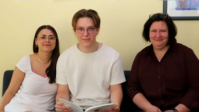 Emily Krauss und Manuel Manske aus dem Abiturjahrgang sehen mit Schulleiterin Andrea Pfeiffer einen Jahresbericht an (von links). (Foto: Oliver Herbst)