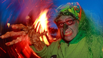 Im Hexenkostüm steht ein Besucher des Walpurgisfestes in Schierke am Feuer. (Foto: Matthias Bein/dpa)