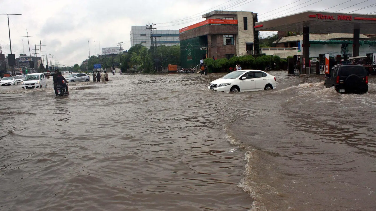 Pendler fahren in Lahore eine überschwemmte Straße entlang. (Foto: Ppi/PPI via ZUMA Press Wire/dpa)
