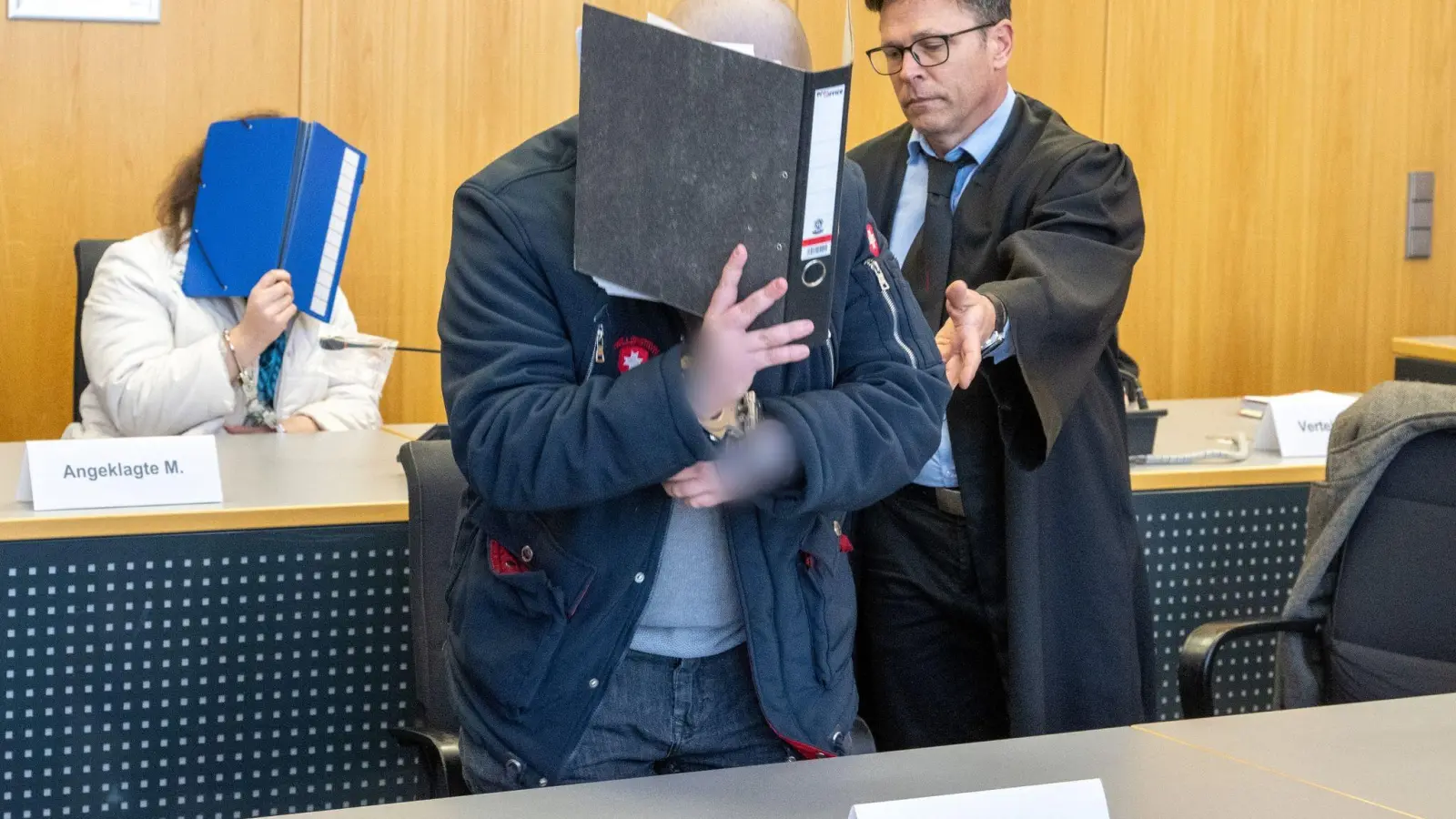 Im Landgericht weist ein Verteidiger seinem Klienten seinen Platz auf der Anklagebank. Dieser musste sich gemeinsam mit seiner Partnerin wegen Mordes verantworten. (Foto: Stefan Puchner/dpa)