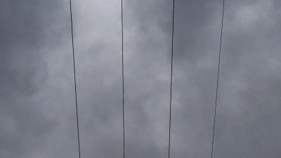 Über den Leitungen eines Strommastes durchziehen Wolken den Himmel. (Foto: Pia Bayer/dpa/Symbolbild)