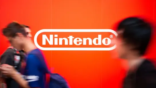 Besucher auf der Gamescom laufen an dem Nintendo-Logo vorbei. (Foto: Christophe Gateau/dpa)