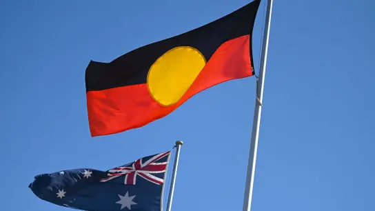Die Flagge der Aborigines (r) ist neben der australischen Flagge zu sehen. (Foto: LUKAS COCH/AAP/dpa)