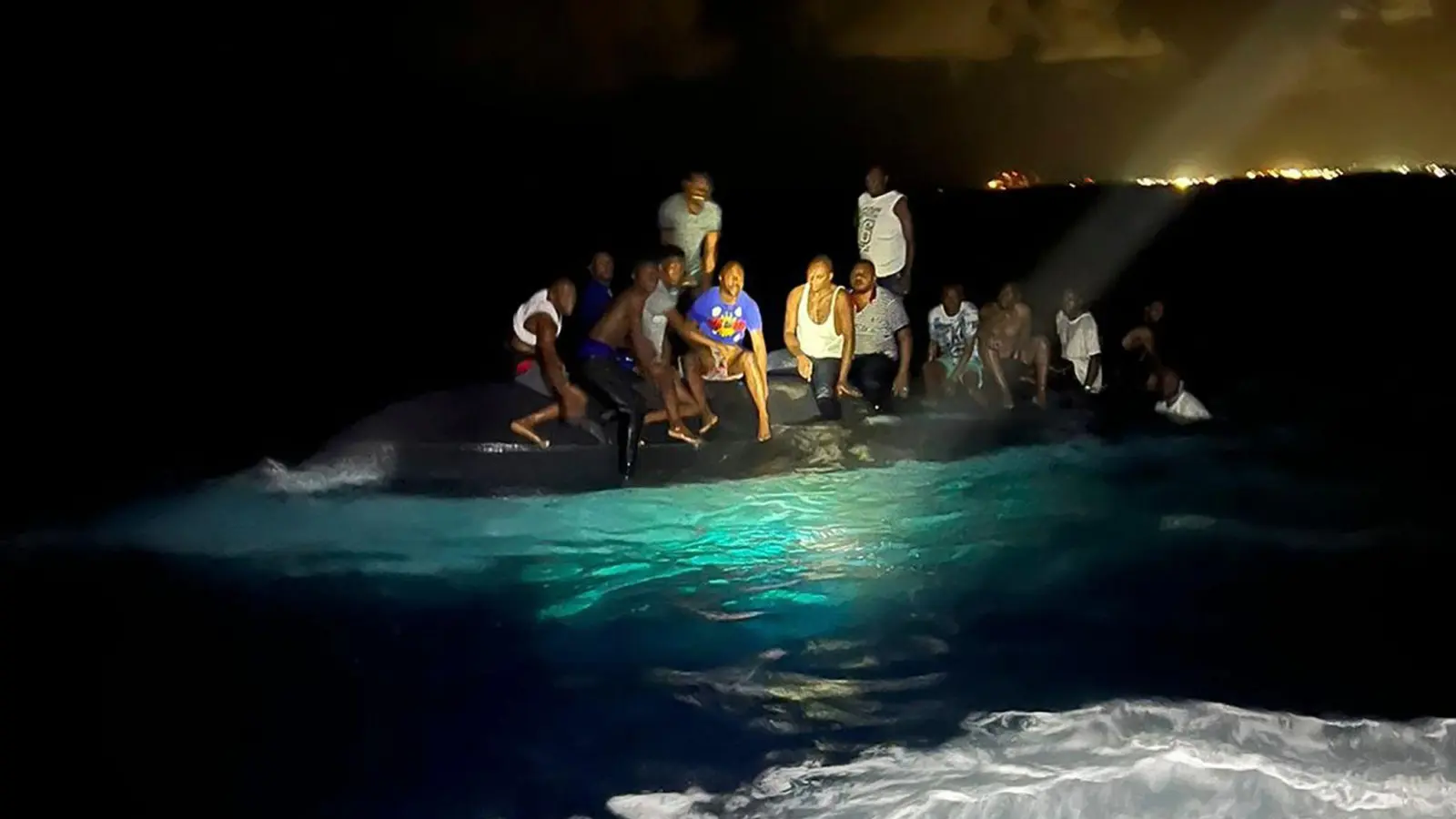 Überlebende sitzen vor ihrer Rettung auf dem gekenterten Boot. (Foto: Uncredited/Royal Bahamas Defense Force/AP/dpa)