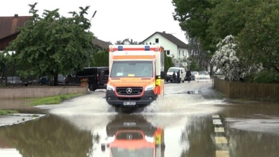 Ein Krankenwagen fährt über eine überschwemmte Straße in Pfaffenhofen an der Ilm. (Foto: -/tv7news/dpa)