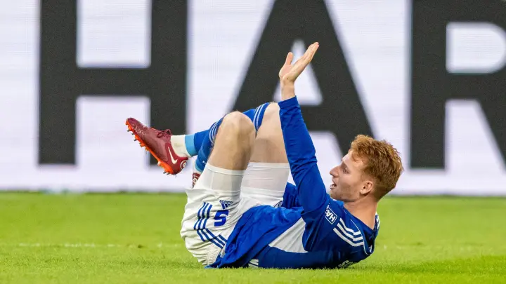 Schalkes Sepp van den Berg ruft nach seiner Verletzung die Betreuer zu sich. (Foto: David Inderlied/dpa)