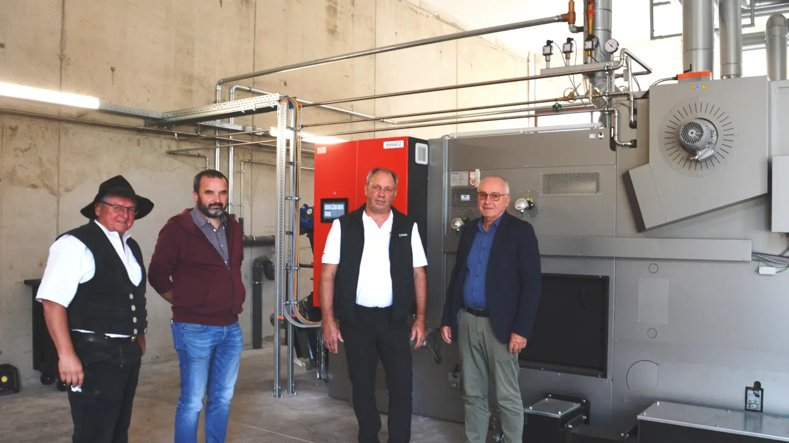 Dicke Leitungen und ein ausgeklügeltes System bestimmen das Innenleben der Heizzentrale (von links): Firmenchef Martin Stark, Stadtbaumeister André Schultz, Projektleiter Werner Schülein und zweiter Bürgermeister Klaus Schülein. (Foto: Peter Tippl)