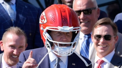 US-Präsident Joe Biden (M) trägt einen Helm von Super-Bowl-Champion Kansas City Chiefs bei einem Besuch im Weißen Haus. (Foto: Evan Vucci/AP/dpa)