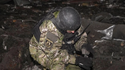 Ein ukrainischer Soldat inspiziert Trümmer eines eingestürzten Gebäudes. (Symbolbild). (Foto: Andrii Marienko/AP/dpa)