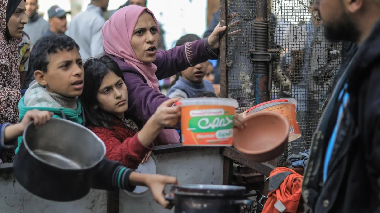 Menschen bitten an einer Essensausgabe in Rafah um Lebensmittel. (Foto: Mohammed Talatene/dpa)