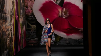 Ein Model trägt eine Kreation von Chanel - im Hintergrund: eine riesige Fototapete. (Foto: Christophe Ena/AP/dpa)