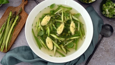 Diese Suppe mit Parmesan-Nocken sowie grünem Spargel und knackigen Kräutern bringt den Frühling in den Suppenteller.   (Foto: Julia Uehren/loeffelgenuss.de/dpa-tmn)