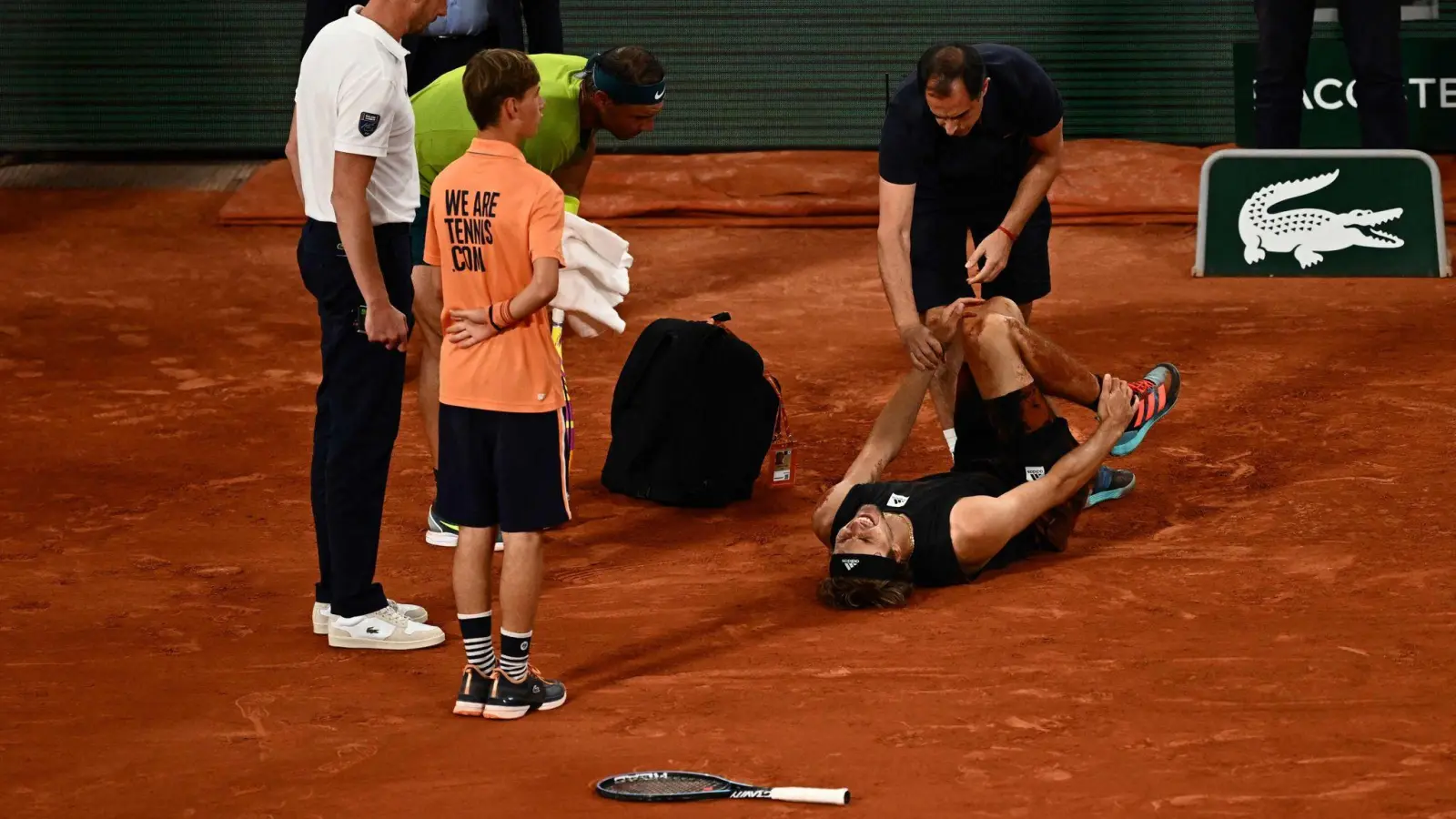 Alexander Zverev (2.v.r) wird während des Spiels gegen Rafael Nadal (2.v.l) medizinisch behandelt. (Foto: Anne-Christine Poujoulat/AFP/dpa)
