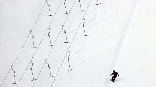 Ein Snowboarder fährt über die Piste. (Foto: Karl-Josef Hildenbrand/dpa/Symbolbild)