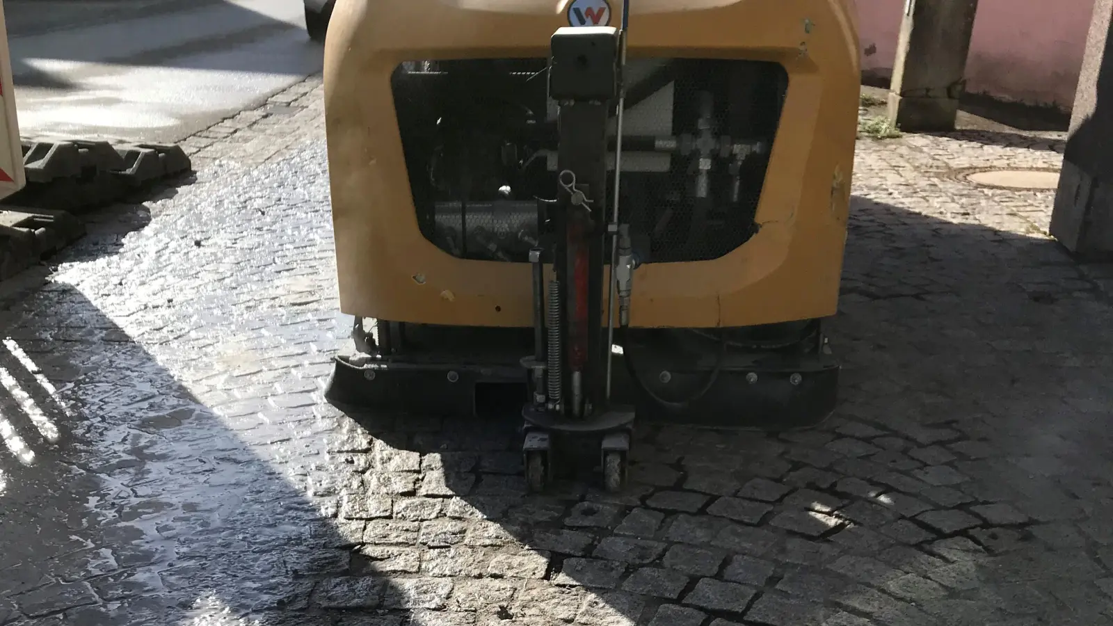Die Schleifmaschine ist vor der Apotheke in Lehrberg in Aktion, um den Gehsteig barrierefrei zu gestalten. (Foto: Gemeinde Lehrberg/Matthias Hüftlein)