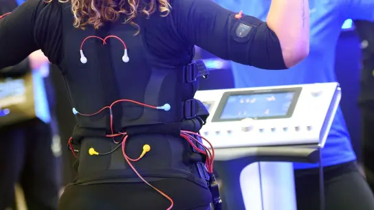 Bei einem EMS-Training trägt man eine verkabelte Weste und Manschetten, über die elektrische Impulse an den Körper weitergeleitet werden. (Foto: Henning Kaiser/dpa-tmn)