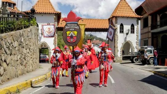 Als Jokili verkleidete Menschen nehmen an einer Parade durch Colonia Tovar teil. (Foto: Pedro Rances Mattey/dpa)