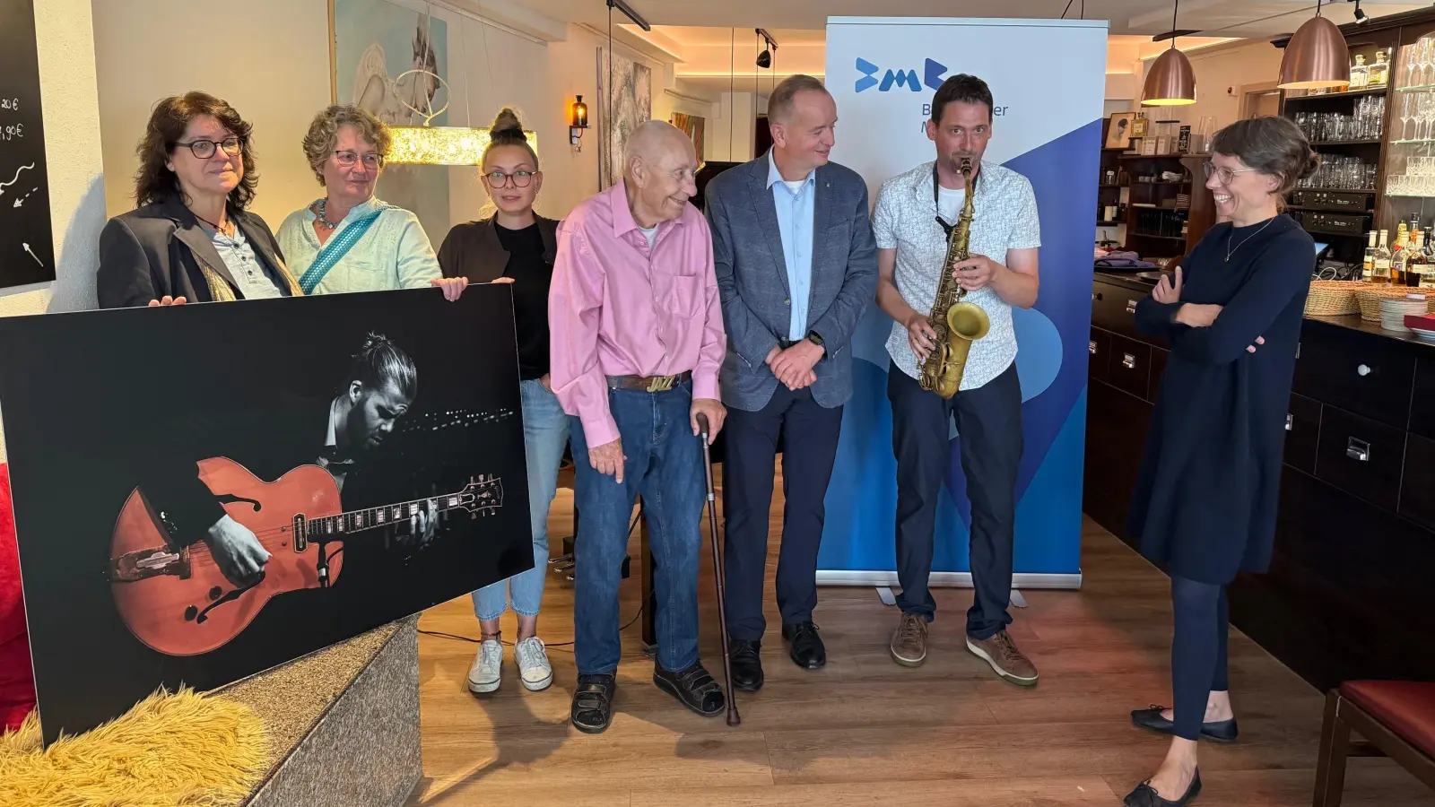 Der Saxophonist Stephan Goldhahn gab eine Kostprobe seines Könnens. Vertreter und Vertreterinnen des Veranstalterteams, der Stadt Ansbach, der Kammerspiele und der Jazztime Ansbach hörten zu (von links): Uli Schwarz, Renate Weinmann, Anna Schuster, Walter L. Henne, Thomas Deffner und Nadja Wilhelm. (Foto: Lara Hausleitner)