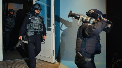 Spezialkräfte verlassen bei einer großangelegten Razzia der Bundespolizei und Landespolizei Brandenburg ein Haus in Weißensee. (Foto: Paul Zinken/dpa)