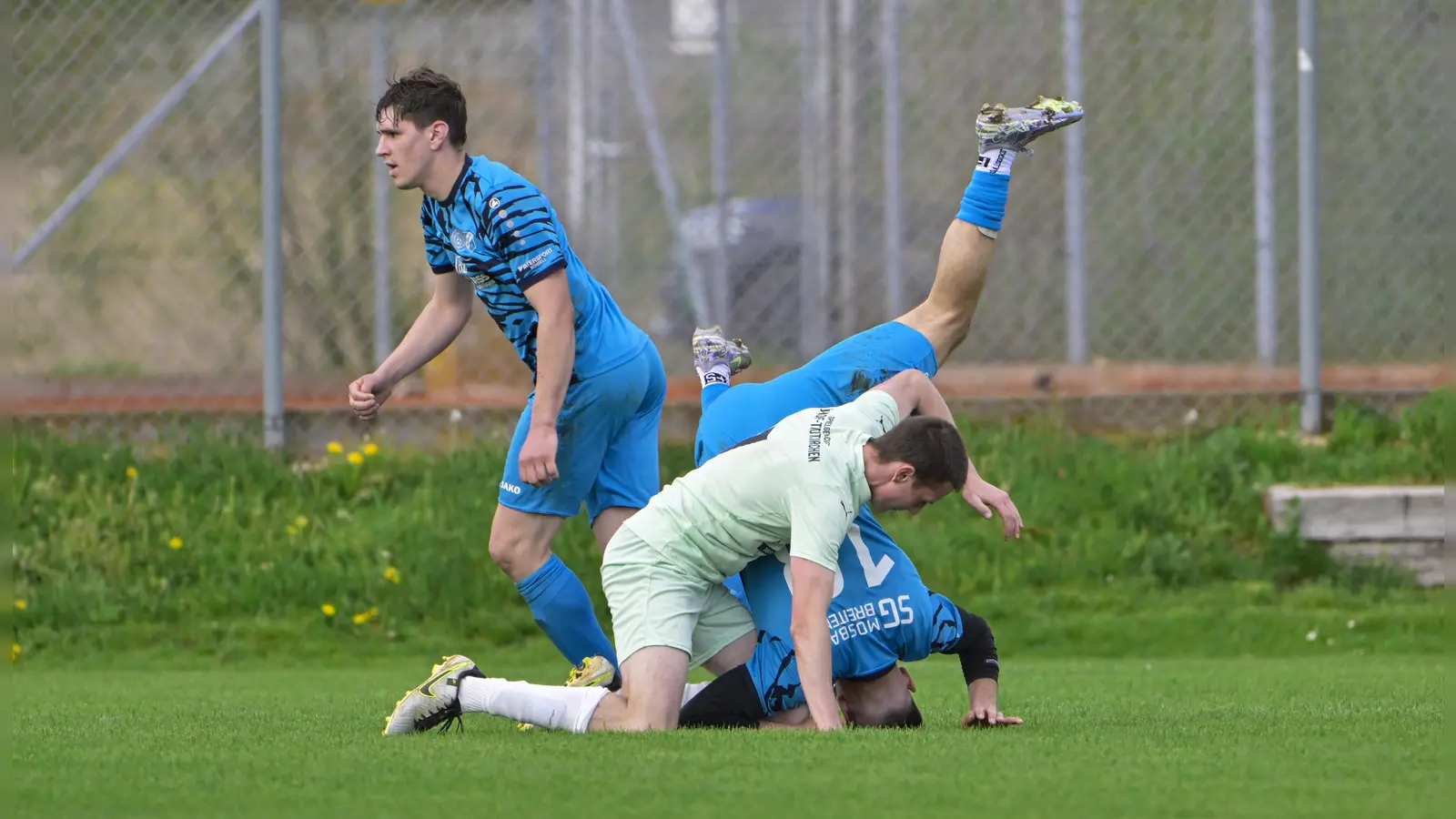 Abstiegskampf pur: In einem Krimi besiegte die SG Neuhof/Trautskirchen (im grünen Trikot Julian Zeilinger) nach 1:3-Rückstand die SG Mosbach-Breitenau (im Kopfstand Naum Veljanovski) noch mit 4:3. Für beide geht es um den Klassenerhalt in direkten Duellen weiter, Mosbach-Breitenau empfängt den TSV Marktbergel, Neuhof/Trautskirchen muss zum TuS Feuchtwangen. (Foto: Martin Rügner)