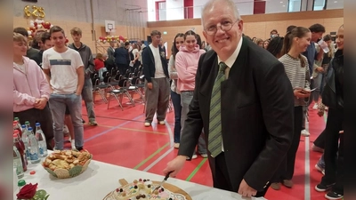 Schulleiter Uwe Nickel schneidet den Geburtstagskuchen an. (Foto: Katrin Merklein)