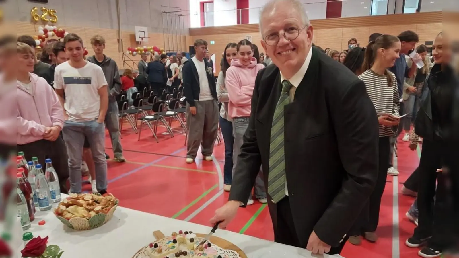 Schulleiter Uwe Nickel schneidet den Geburtstagskuchen an. (Foto: Katrin Merklein)