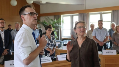 Landrat Dr. Christian von Dobschütz (mit Mikrofon) nimmt dem neuen Kreistagsmitglied Luise Fröhlich den Amtseid ab. Die Eidesformel, die die Grünen-Rätin dabei nachzusprechen hatte, war an die Wand des Sitzungssaals projiziert. (Foto: Andreas Reum)