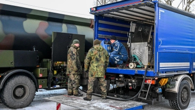 Die Bundeswehr unterstützt das Technische Hilfswerk bei der Betankung mit Diesel, der für Notstromaggregate benötigt wird.  (Foto: Jens Kalaene/dpa)