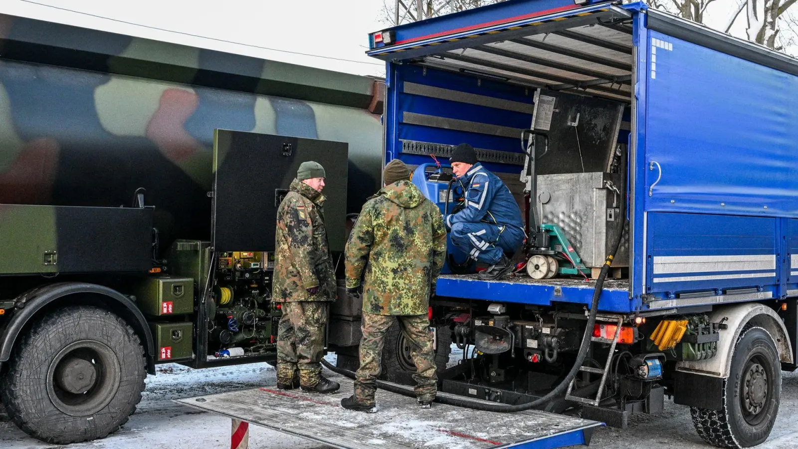 Die Bundeswehr unterstützt das Technische Hilfswerk bei der Betankung mit Diesel, der für Notstromaggregate benötigt wird.  (Foto: Jens Kalaene/dpa)